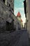 City street of the old city in Tallinn with an ancient wall of limestone and red tile roofs on the towers.