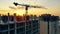 City sunset with a crane and multistory houses getting built