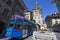 A city tram under the Kafigturm clock tower and the Anna Seiler fountain in the city center of