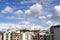 City under blue sky with scenic fluffy clouds.