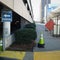 City Urbanscape and Sidewalk Scene with Visitor Parking Directional Sign, Parking Garage and Traffic Cone.