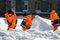 City utility workers in bright orange suits remove snow from city streets: Kaluzhskiy region, Russia - February 2021