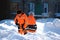 City utility workers in bright orange suits remove snow from city streets: Kaluzhskiy region, Russia - February 2021