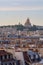 City view of Parisian rooftops and Sacre-Coeur minor basilica. Sacred Heart church in Montmartre hill. Landmark in Paris, France.