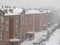 City winter landscape. Blizzard. Snowstorm and heavy snow in a  town. Real snow is falling. Brick residential building in the snow