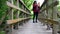 City woman in red jacket on wooden footbridge