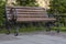 City wooden bench with swirl shape legs on sunny summer day. Copy space