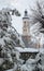 City â€‹â€‹bell tower, snowy fir trees, winter, tracks in the snow