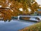 Cityscape with bridge over pond in autumn park