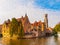 Cityscape of Bruges, Flanders, Belgium. Water canal at Rozenhoedkaai with old brick buildings and Belfry Tower on
