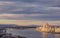 Cityscape of Budapest with bright parliament illuminated by last sunshine before sundown and Danube river with bridge.