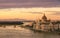 Cityscape of Budapest with bright parliament illuminated by last sunshine before sundown and Danube river with bridge.