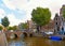 Cityscape with canal in Amsterdam city. Picturesque town landscape with people, bridge and old buildings facade in Net