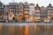 Cityscape - evening view of the houses with festive decorations and the city channel with boats, city of Amsterdam