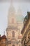 Cityscape on a foggy morning - view of the Church of Saint Nicholas in the Mala Strana historical neighbourhood of Prague