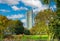 Cityscape with green park, modern Gap 15 tower building, blue autumn sky