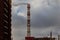 The cityscape, the high chimney boiler room against the sky.