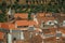 Cityscape with many rooftops, steeple and fields