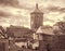 Cityscape of the medieval town with gates tower. Retro toned.