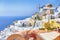 Cityscape of Oia Village in Santorini Island Located on Volcanic Calderra at Daytime. Traditional Windmills on Background