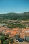 Cityscape with old building roofs and green hills