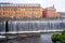 Cityscape of old industrial buildings with waterfall and water reservoir in the city of Norrkoping Sweden.