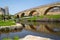 Cityscape scene of downtown Minneapolis, as seen from Mill Ruins Park. View of the Stone Arch bridge on sunny spring day