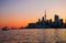 Cityscape - silhouettes of skyscrapers, calm lake old sail ship and yacht.