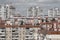 Cityscape of a stuffy post-Soviet city, densely built up with multi-storey residential panel buildings in red and white colors