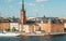 Cityscape with towers of Stockholm, water around and touristic boat on cruise through the islands.