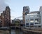 cityscape view of leeds with the river aire entering the dark arches under the railway buildings with pedestrian footbridge and