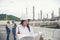 Civil Engineer holding portable radio, blueprint at refinery plant. Asian woman engineering fill out form and inspect at