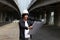 Civil engineer man with helmet, standing and looks at the project drafts while on parallel expressway background