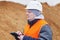 Civil engineer with tablet PC at a pile of sand