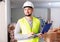 Civil engineer working on a construction site indoors monitors the process of capital repairs of a brick house on laptop