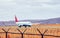 Civilian passenger plane accelerates along the runway on the airport field against the background of dry grass