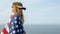 Civilian woman in her husband`s military cap. A widow with a flag of the united states left without her husband. Memorial Day to