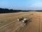 Claas 8900 harvester combine offloading to tractor in the field in Faxe, Denmark