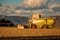 A Claas Harvester working in a rural field on a summer evening