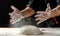 Clap hands of baker with flour. Beautiful and strong men`s hands knead the dough make bread, pasta or pizza. Powdery flour flying