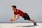 Clap pushup fitness man doing plyometrics push-up explosive workout for muscles training. Athlete working out on gym