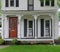 Clapboard house with large open porch and rocking chairs