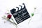 Clapperboard and fresh roses on marble table. Love is just acting concept.