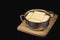 Clarification of butter, butter cubes in a steel pot on a chopping board and black isolated background