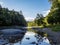 Clarion River in Cooks Forest State Park in Pennsylvania right before sunset with a soft sky reflecting in the river and the