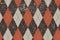 Clasic argyle aged pattern. Traditional diamond check seamless print in brown, red and ocher and grunge texture. Grunge vintage