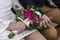 Clasped hands of the bride and the groom with the bride holding a beautiful bouquet