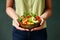 Clasping a Bowl Overflowing with a Delectable Salad, Enriched with Avocado, Tomato, and a Harmony of Healthy Vegetables