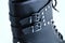 Clasps black boots close-up with metal rivets. White background