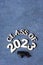 Class of 2023 concept. Wooden number 2023 with graduate hat on dark concrete background with tinsel